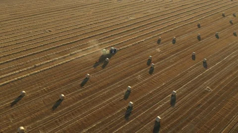 Aerial view of tractor tow trailed bale machine to collect straw v Stock Footage 300245891