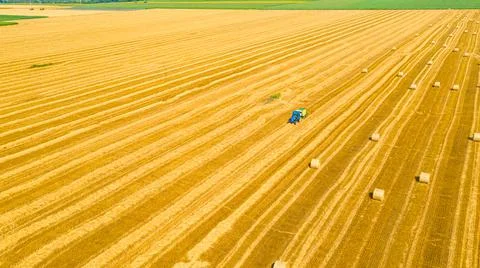 Aerial view of tractor tow trailed bale machine to collect straw from harvest Stock Photos