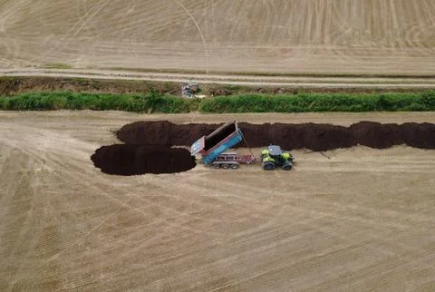 Aerial View of Tractor Unloading Organic Material on Field Stock Photos