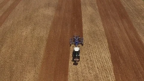 Aerial view of a tractor at work on a agricultural fields - cultivating a field Stock Footage 74987767