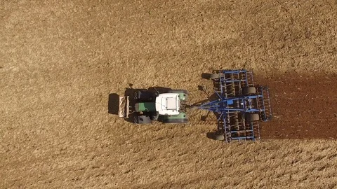 Aerial view of a tractor at work on agricultural fields - cultivating a field Stock Footage 74987796