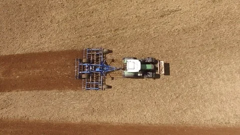Aerial view of a tractor at work on a agricultural fields - cultivating a field Stock Footage 74990968