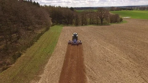 Aerial view of a tractor at work on a agricultural fields - cultivating a field Stock Footage 74990982