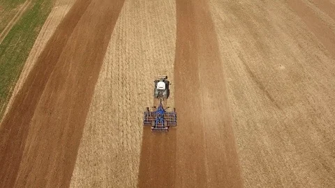 Aerial view of a tractor at work on a beautiful agricultural fields in spring Stock Footage 74987733