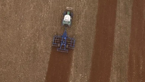 Aerial view of a tractor at work on a beautiful agricultural fields  - top view Stock Footage 74990998