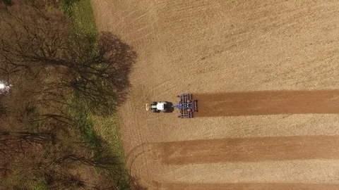 Aerial view of a tractor at work - tractor plough cultivating beautiful fields Stock Footage 74992816