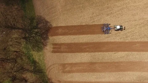 Aerial view of a tractor at work - tractor plough cultivating beautiful fields Stock Footage 74992849