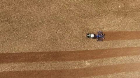 Aerial view of a tractor at work - tractor plough cultivating beautiful fields Stock Footage 74993041