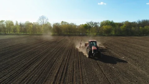 Aerial view of tractor working in the dust field with a modern sowing seeds Stockbeeldmateriaal 129052954