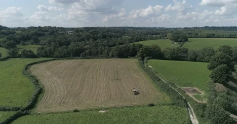 Aerial view of a tractor working on a field in the English countryside Stock Footage 79664258