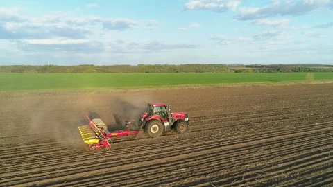 Aerial view of tractor working in the field with a modern sowing seeds machine Stockbeeldmateriaal 129755775