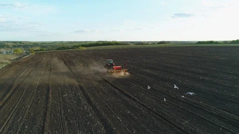 Aerial view of tractor working in the field with a modern sowing seeds machine Vídeos de archivo 129758519