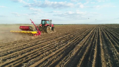 Aerial view of tractor working in the field with a modern sowing seeds machine Stockbeeldmateriaal 129759035