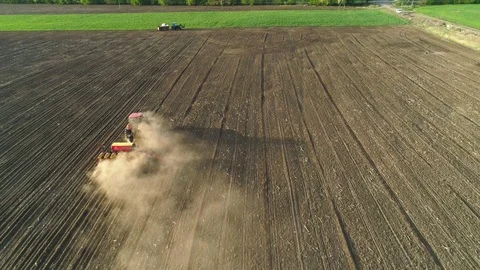 Aerial view of tractor working in the field with a modern sowing seeds machine Stock Footage 129759892