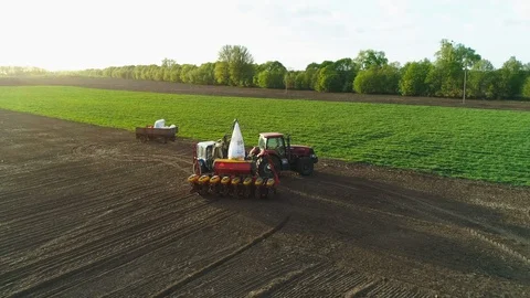 Aerial view of tractor working in the field with a modern sowing seeds machine Stock Footage 129760487