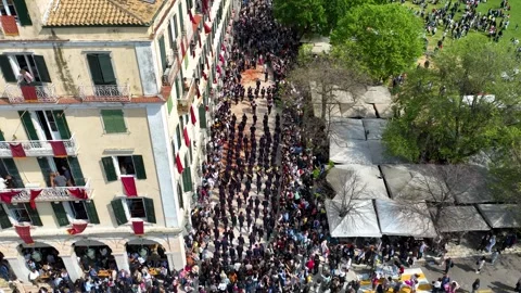 Aerial view of traditional Corfu Easter marching band procession through narrow Stock Footage 333798656