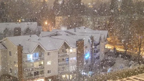 Aerial view of traffic flow and low rise apartment on cold blizzard snow winter Stock Footage 83636733