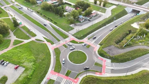 Aerial view of traffic flow at a roundabout intersection showcasing vehicles Stock Footage 347789693