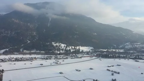 An aerial view of a train in the Alps in Bavaria near the village of Farchant. Stock Footage 257954681