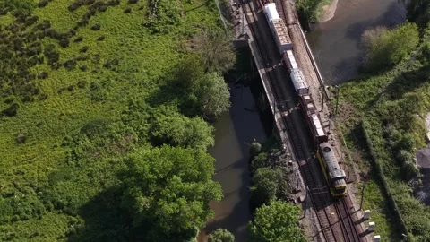 Aerial view of train carrying shipping containers on tracks near river, Stock Footage 332797204