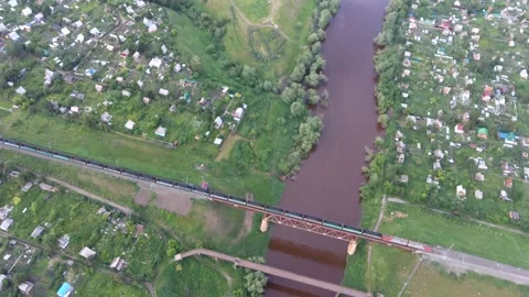 Aerial view to train crossing the bridge in industrial area of Russian town Stock Footage 142278617