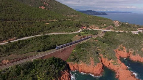Aerial view of train crossing rugged terrain near Saint Raphael, France Stock Footage 310639355