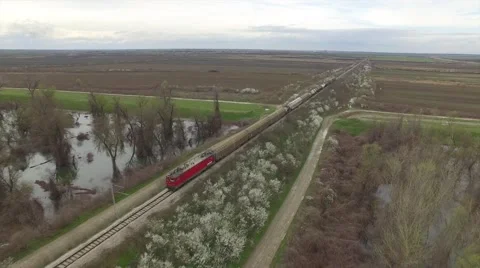 Aerial view of train going through fields and river Stock Footage 61102334
