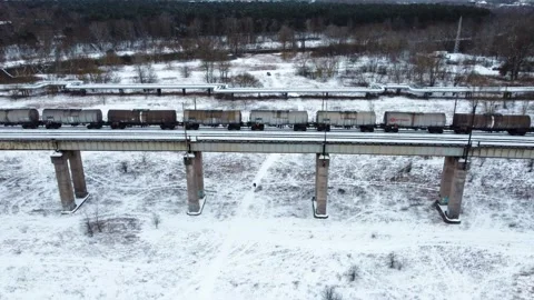 Aerial View of Train Moving Along the Snow Covered Railway Overpass Bridge Stock Footage 332058062
