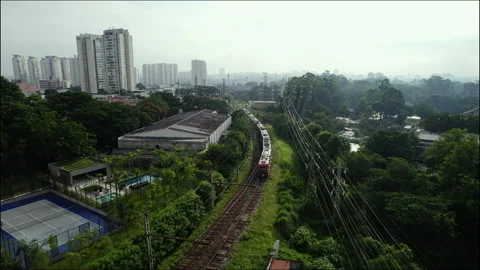 Aerial view of a train moving through the Parque Villa Lobos favela in Sao Vídeo Stock 234840274