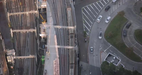 Aerial view train moving on tracks in Tokyo with cars on urban roads motion Stock Footage 323588248