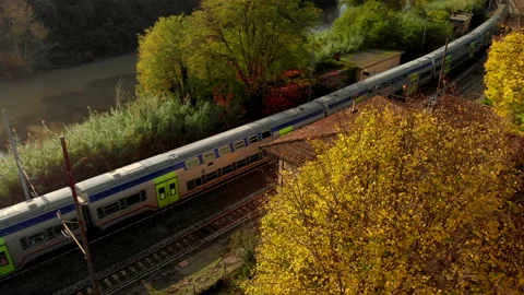 Aerial view of a train passes through an abandoned station in autumn Stock Footage 142614397