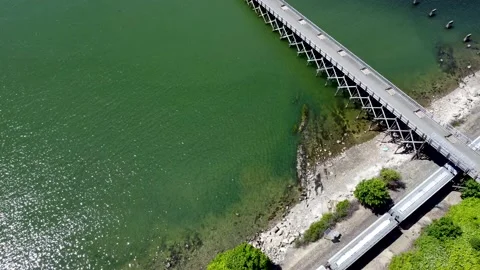 Aerial view of train passing beneath pier in Boulevard Park Stock Footage 155826379