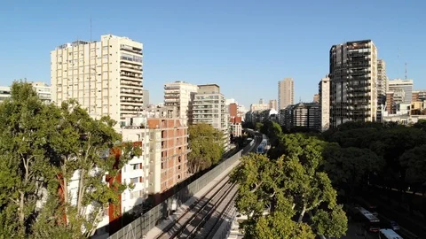 Aerial view of a train passing over an elevated rail track in Belgrano, Buenos Stock Footage 126567771