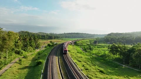 Aerial View of Train Passing Through a Lush Countryside Stock Footage 269743260