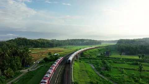 Aerial View of Train Passing Through a Lush Countryside Stock Footage 269747527
