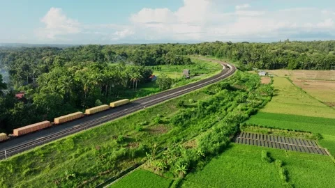 Aerial View of Train Passing Through a Lush Countryside Stock Footage 269750978