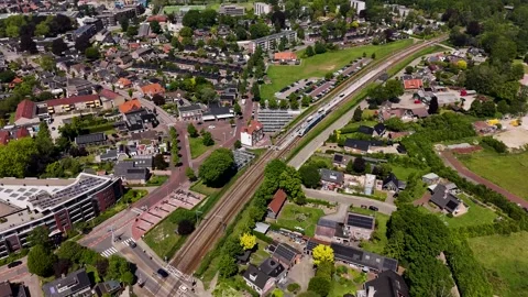 Aerial view of a train passing through a suburban residential area in netherland Видео 336594859