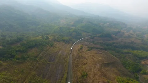 Aerial view of train passing through green hills in Haflong Stock Footage 342143204