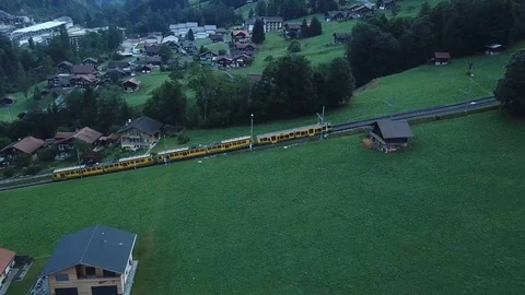 Aerial view of train passing in touristic town in a valley of Switzerland 3 Stock Footage 95080134