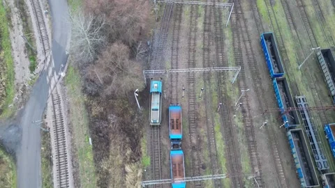 Aerial view of a train on railway tracks, showcasing gradual movement through Видео 335886500