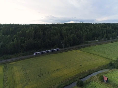 Aerial view of train riding forward near farm fields and forest. Drone filming Video stock 79325287