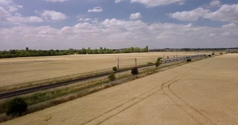 Aerial view of the train running through the field in Cambridge, United Kingdom. Stock Footage 103237104