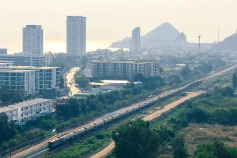 Aerial view of train running through small city by the sea in morning Stock Photos