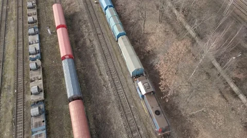 Aerial view of Train slowing riding between other cargo trains Stock Footage 219744973