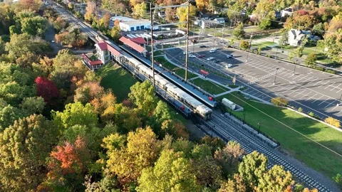 Aerial View of Train At Station Surrounded by Fall Colors Stock Footage 229452159