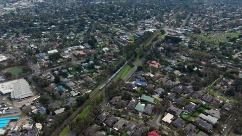 Aerial view of a train traveling through a suburban neighborhood Stock Footage 339376863