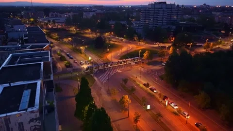 Aerial view of tram crossing intersection in Quartier de l'Etoile at night in Stock Footage 336383513