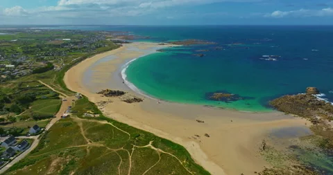 Aerial view of the tranquil beach at Plage des Amiets with clear turquoise water 스톡 동영상 311487720