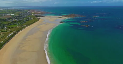 Aerial view of the tranquil beach at Plage des Amiets with clear turquoise water Stock Footage 311574134