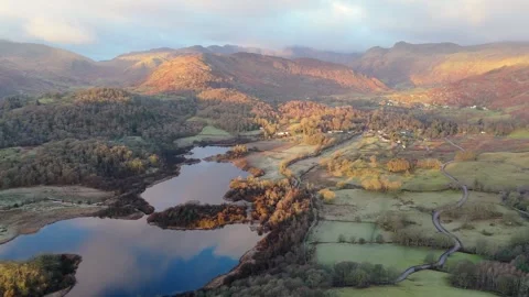 Aerial view of a tranquil lake surrounded by autumn forests and mountains. Stock Footage 316064406